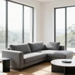 Modern L-shaped sectional sofa in gray fabric positioned in contemporary living room with minimalist decor