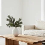 Modern minimalist Christmas decorations featuring white candles, natural wood elements, and simple greenery on neutral backgr