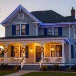 Brightly lit house exterior with colorful Christmas light displays wrapping around roof and trees