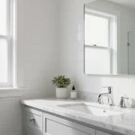 Modern bathroom with neutral tiles, classic fixtures, and minimalist storage showcasing timeless design elements